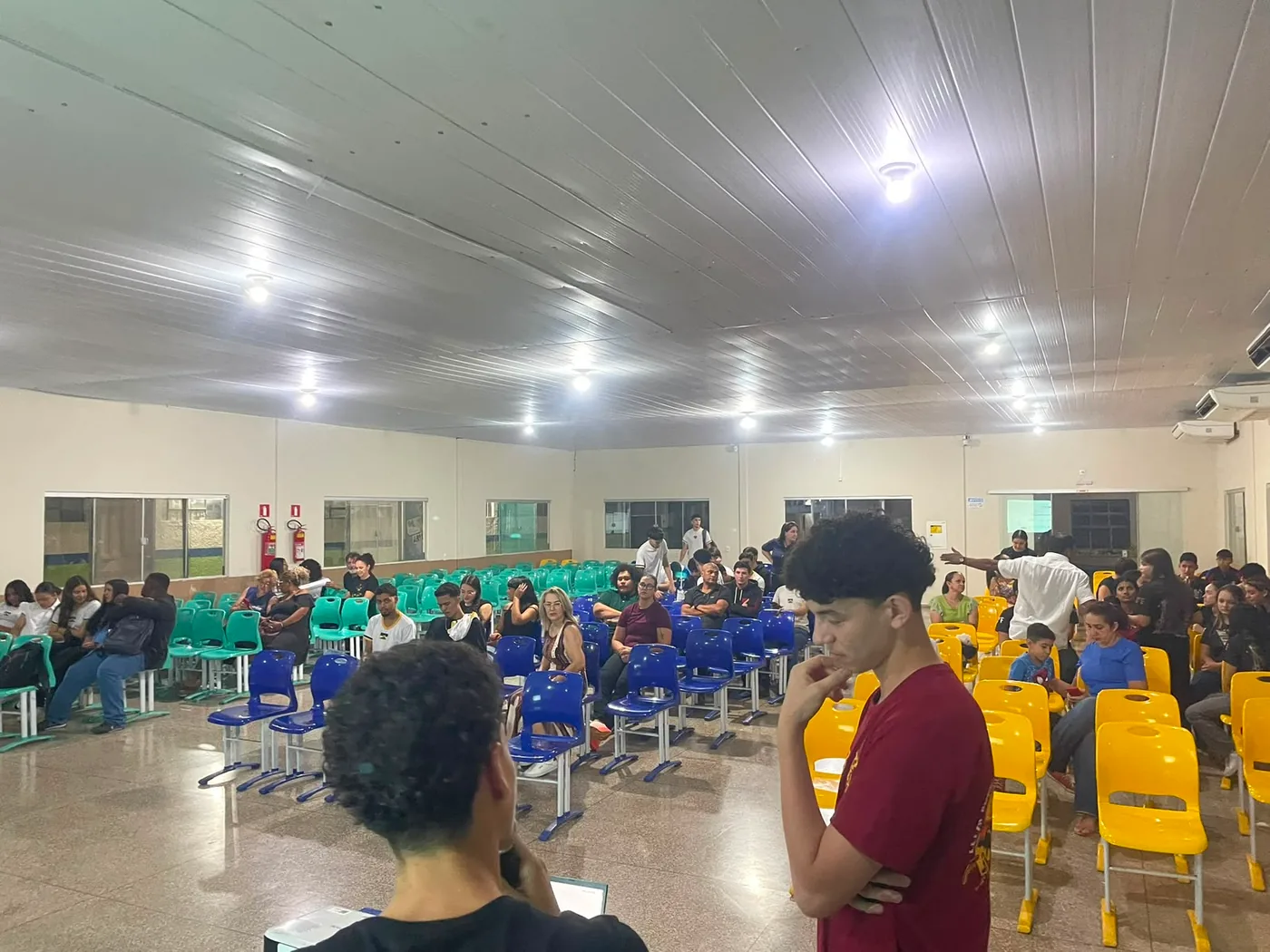 Jovens e familiares reunidos durante uma apresenta&ccedil;&atilde;o do projeto